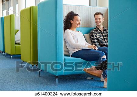 Picture - University students relaxing in modern cubicle seating area. Fotosearch