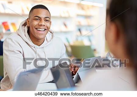 Stock Photo - University students using laptops and digital tablet, working together. Fotosearch