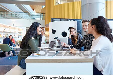 Stock Photo - University students using laptops and digital tablet, working together. Fotosearch