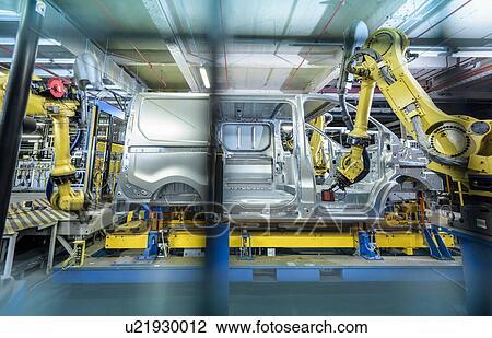 Stock Image - Vehicle and robots on production line in car factory. Fotosearch