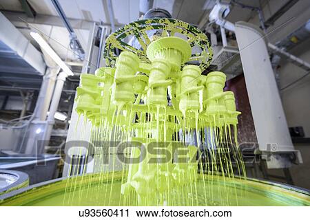 Stock Image - Wax components being coated in ceramic mixture in precision casting factory. Fotosearch