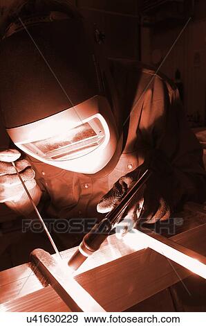 Stock Photo - Welder wearing protective mask. Fotosearch