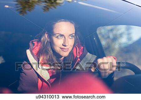 Stock Image - Windscreen view of woman driving car. Fotosearch