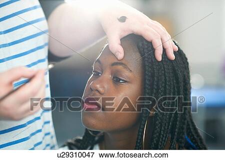 Woman applying make-up to young woman View Large Photo Image Stock Photo - Woman applying make-up to young woman. Fotosearch