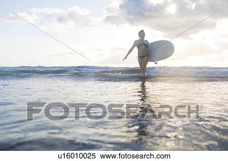 Woman carrying surfboard in sea, Nosara, Guanacaste Province, Costa Rica View Large Photo Image Stock Photography - Woman carrying surfboard in sea, Nosara, Guanacaste Province, Costa Rica. Fotosearch
