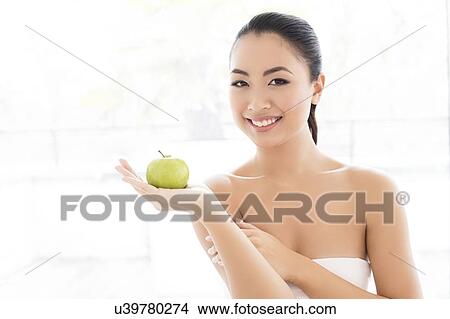Picture - Woman holding apple. Fotosearch