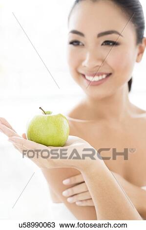 Stock Image - Woman holding apple. Fotosearch