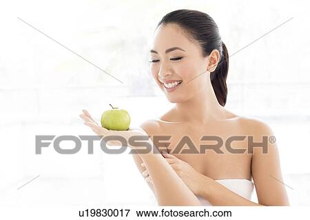 Woman holding apple View Large Photo Image Stock Photo - Woman holding apple. Fotosearch