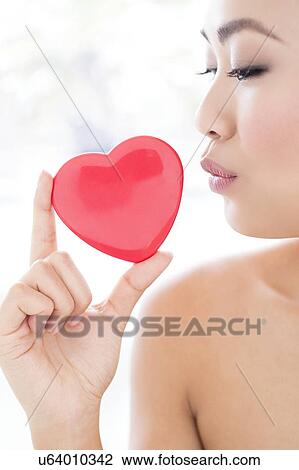 Stock Image - Woman holding heart. Fotosearch