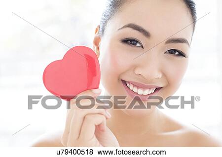 Stock Photo - Woman holding heart. Fotosearch