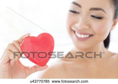 Stock Photography - Woman holding heart. Fotosearch