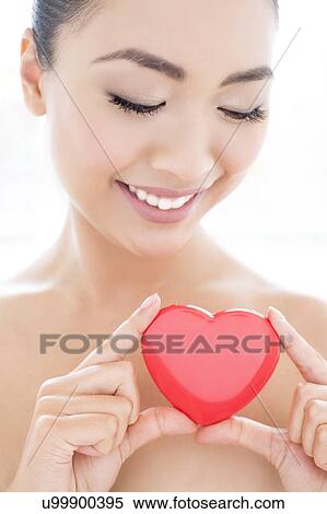 Stock Photography - Woman holding heart. Fotosearch