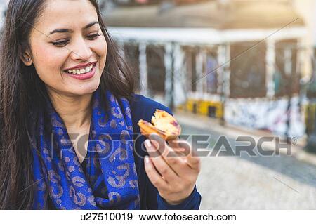 Stock Photo - Woman holding pastel de nata, Lisbon, Portugal. Fotosearch