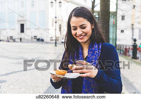 Stock Photo - Woman holding pastel de nata, Lisbon, Portugal. Fotosearch