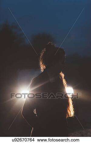 Woman in front of car headlights on roadside at night View Large Photo Image Picture - Woman in front of car headlights on roadside at night. Fotosearch