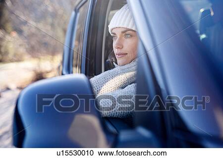 Stock Image - Woman in knit hat gazing from car window. Fotosearch