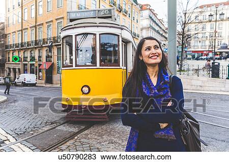Stock Image - Woman in street by tram, Lisbon, Portugal. Fotosearch