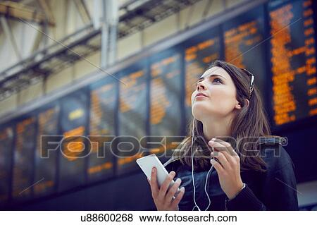 Woman looking at departure information, London, UK View Large Photo Image Stock Photo - Woman looking at departure information, London, UK. Fotosearch