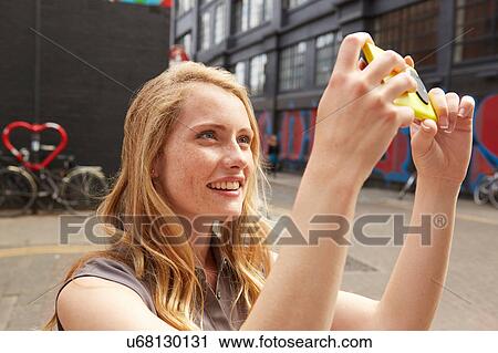 Woman taking selfie in street, London, UK View Large Photo Image Stock Image - Woman taking selfie in street, London, UK. Fotosearch