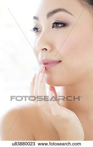 Stock Image - Woman touching lip. Fotosearch