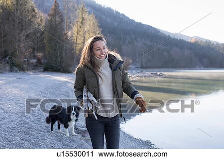 Woman walking dog on lakeside in Bavarian Alps View Large Photo Image Stock Image - Woman walking dog on lakeside in Bavarian Alps. Fotosearch