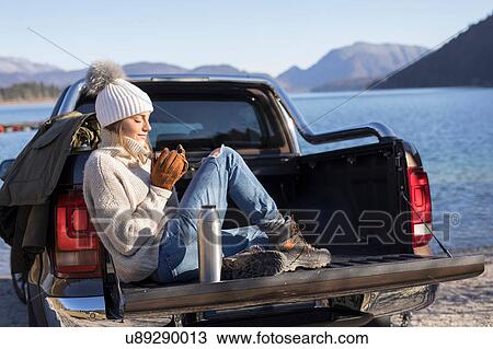 Woman with coffee sitting on pick up at lakeside in Bavarian Alps View Large Photo Image Stock Image - Woman with coffee sitting on pick up at lakeside in Bavarian Alps. Fotosearch