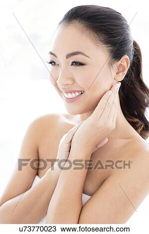 Stock Image - Woman with hands touching face. Fotosearch