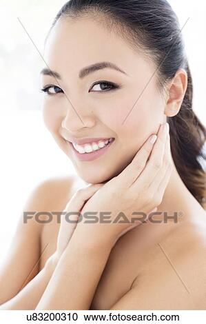 Stock Image - Woman with hands touching face. Fotosearch