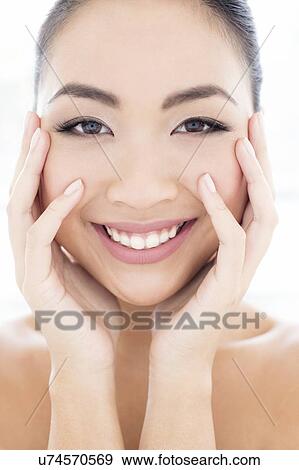 Stock Photo - Woman with hands touching face. Fotosearch