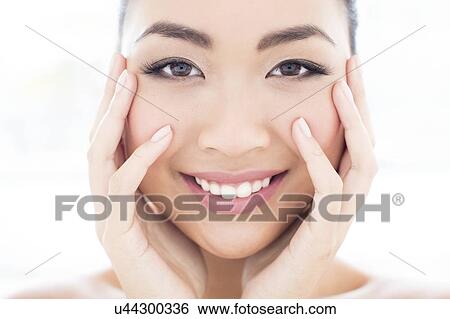 Woman with hands touching face View Large Photo Image Stock Photograph - Woman with hands touching face. Fotosearch