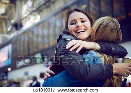 Women hugging in train station concourse, London, UK View Large Photo Image Stock Photo - Women hugging in train station concourse, London, UK. Fotosearch