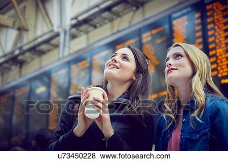 Women looking at departure information, London, UK View Large Photo Image Stock Photo - Women looking at departure information, London, UK. Fotosearch