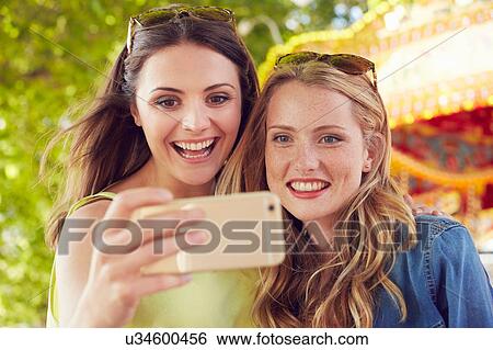 Women taking selfie, carousel in background, London, UK View Large Photo Image Stock Photograph - Women taking selfie, carousel in background, London, UK. Fotosearch