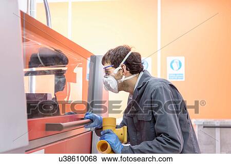 Stock Photo - Worker 3D printing components in precision casting factory. Fotosearch