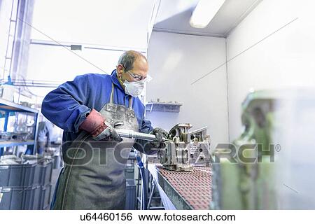 Worker finishing aluminium part in precision casting factory View Large Photo Image Stock Photograph - Worker finishing aluminium part in precision casting factory. Fotosearch