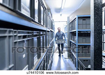 Stock Photograph - Worker in storage area of precision casting factory. Fotosearch
