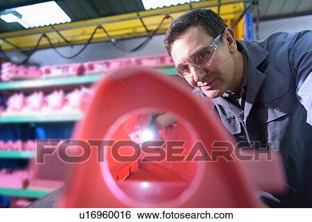 Stock Photograph - Worker inspecting wax components in precision casting factory. Fotosearch
