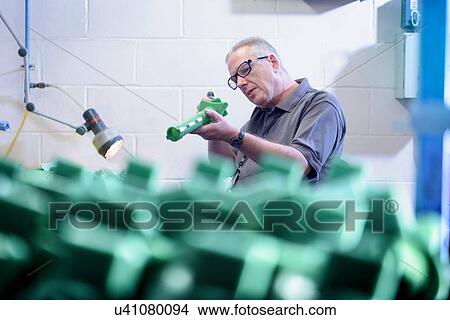 Picture - Worker preparing wax component in precision casting factory. Fotosearch