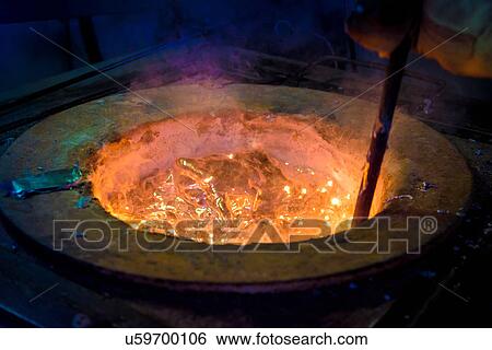 Stock Photograph - Worker stirring molten aluminium alloy in precision casting factory, close up. Fotosearch