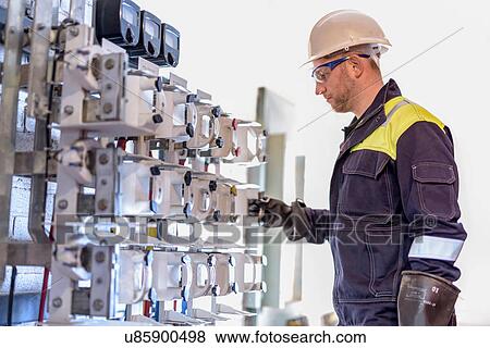 Stock Photo - Worker testing circuit breakers in electricity substation. Fotosearch