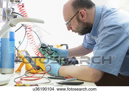 Worker testing electrical components in laboratory View Large Photo Image Picture - Worker testing electrical components in laboratory. Fotosearch