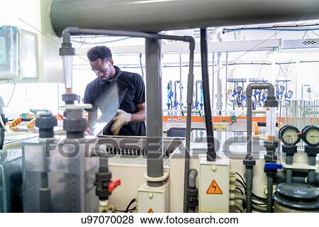 Worker using circuit board processing machine in electronics factory View Large Photo Image Stock Photo - Worker using circuit board processing machine in electronics factory. Fotosearch