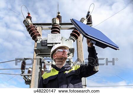 Stock Photo - Worker using partial discharge detector in electricity substation. Fotosearch
