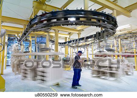 Worker with ceramic shelled wax components in drying area of precision casting factory View Large Photo Image Stock Photo - Worker with ceramic shelled wax components in drying area of precision casting factory. Fotosearch