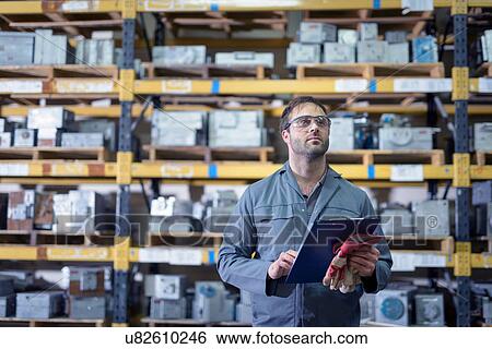 Stock Photograph - Worker with steel moulds in precision casting factory. Fotosearch