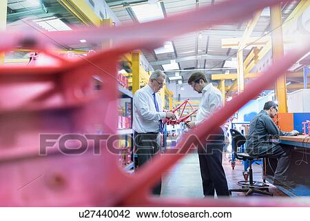 Stock Image - Workers inspecting wax components in precision casting factory. Fotosearch