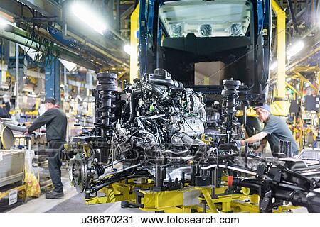 Stock Image - Workers on production line in car factory. Fotosearch