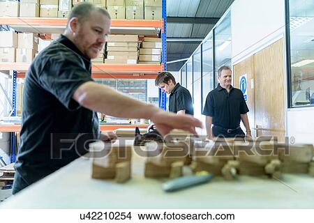 Picture - Workers sorting pre-cut circuit boards in electronics factory. Fotosearch