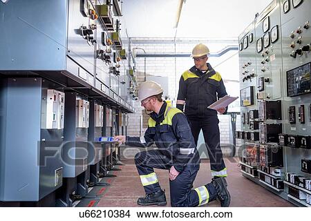 Picture - Workers testing for noise in electricity substation. Fotosearch