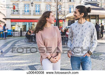 Stock Photo - Young couple, walking outdoors, smiling, Lisbon, Portugal. Fotosearch